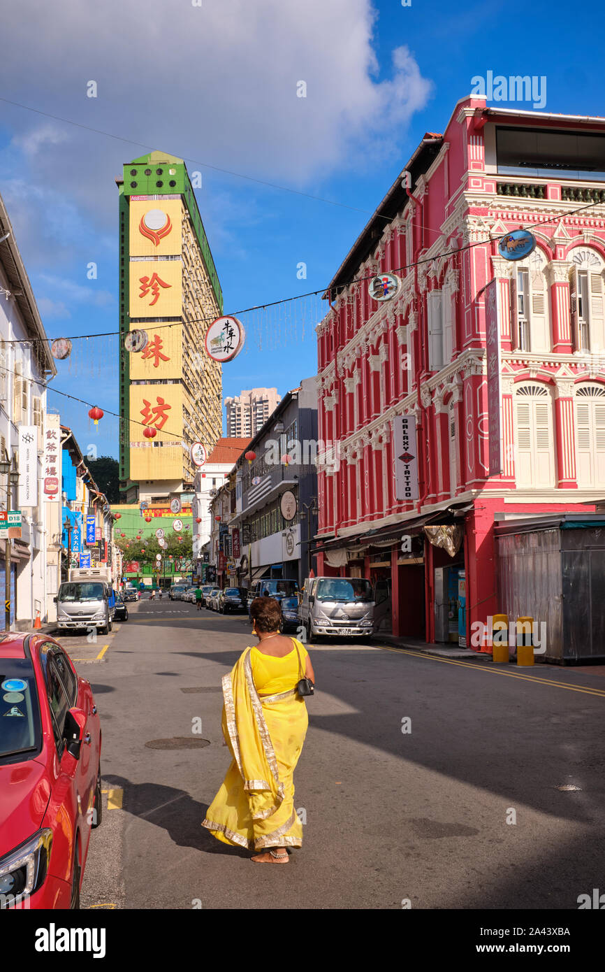 A sari-clad Indian woman walks barefoot from a nearby Hindu temple through Temple St., Chinatown, Singapore, adding more color to the pretty street Stock Photo