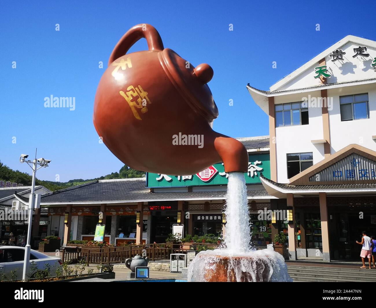 A giant floating teapot and teacup water fountain is displayed at an