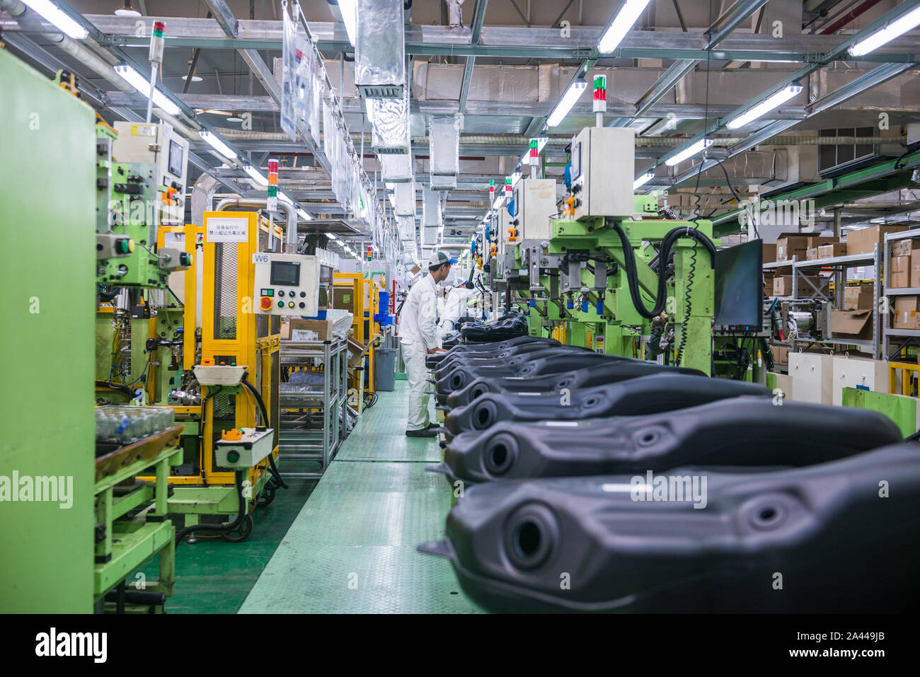 --FILE--A Chinese worker checks fuel tanks of vehicles on the assembly ...