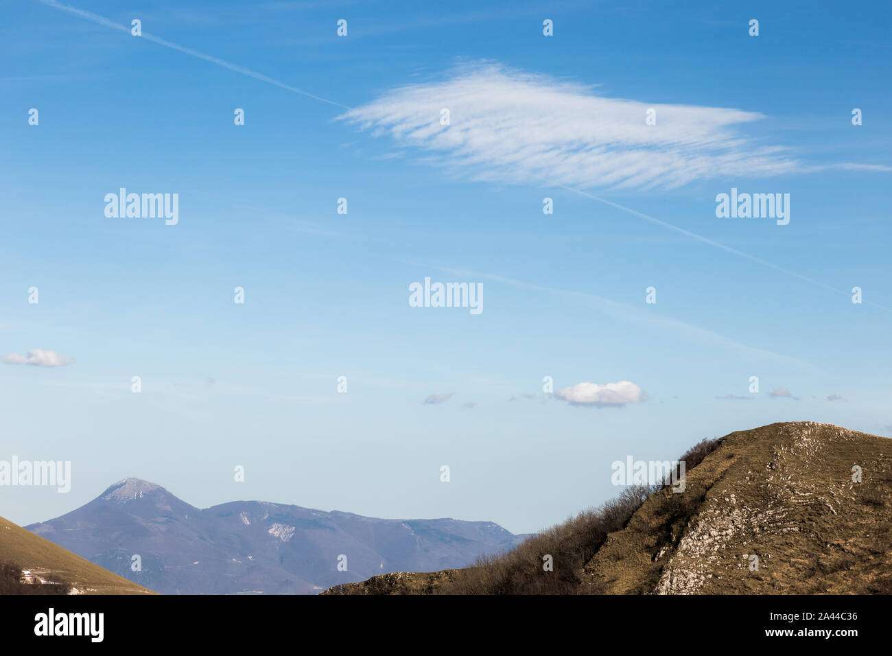 Mountain top under a deep ,blue sky, with a white cloud Stock Photo