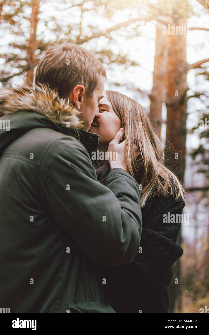 Happy young couple in love friends dressed in casual style walking together on nature park forest in the cold season, family advenure travel Stock Photo