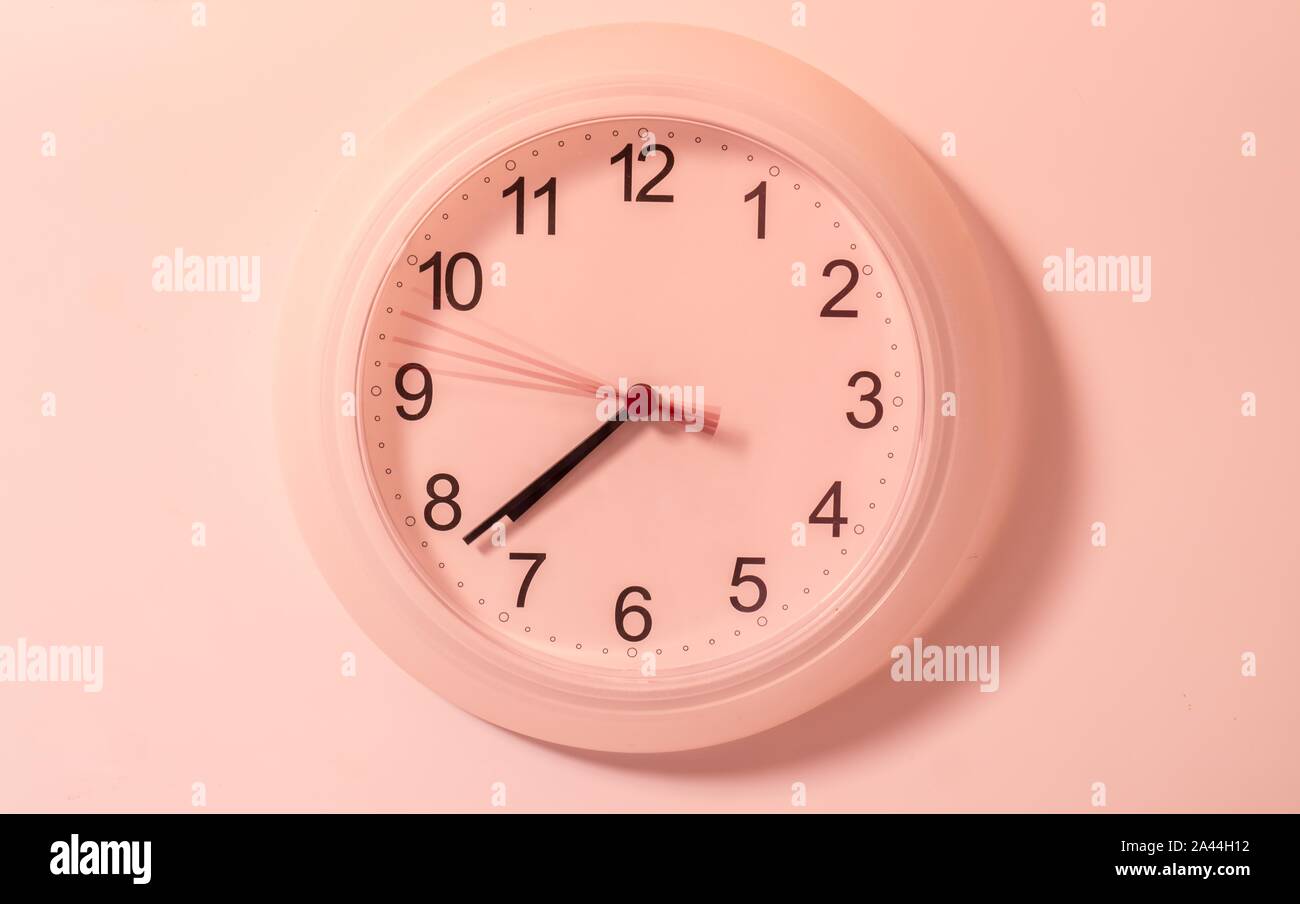 Round wall clock on the white wall Stock Photo