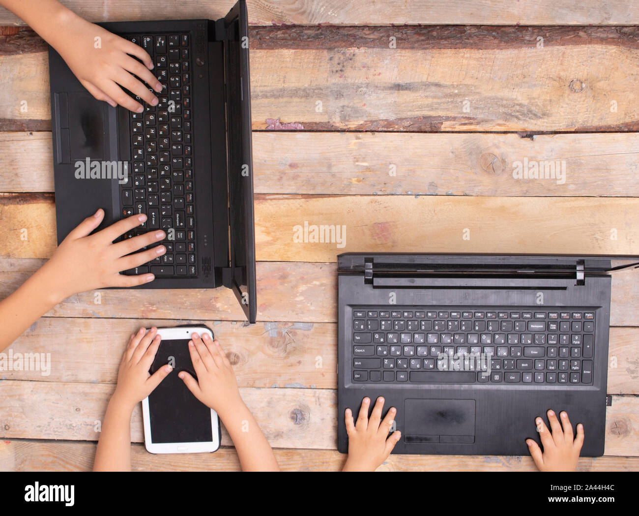 children sitting at the computers, holding tablet Stock Photo