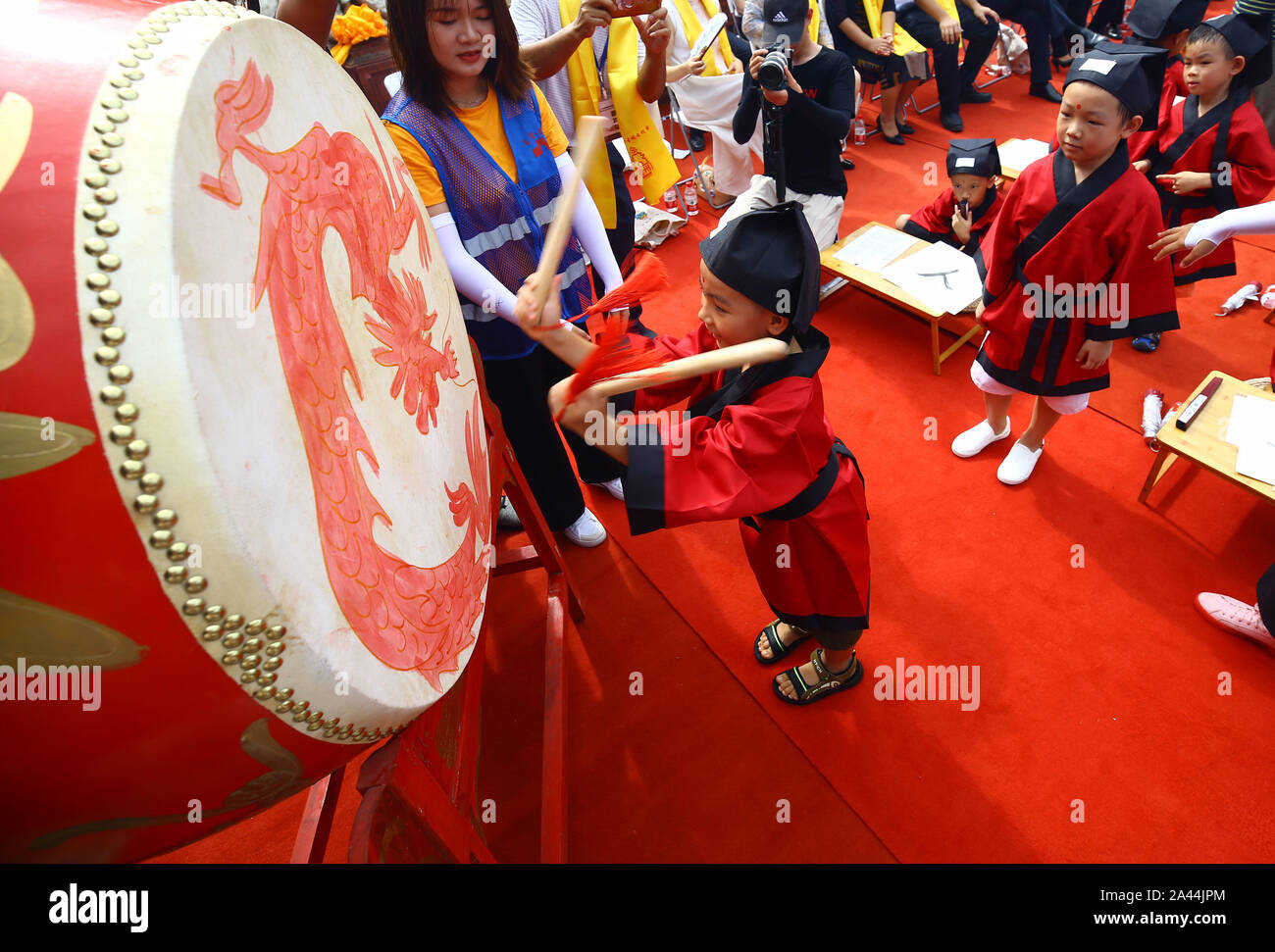 Over 30 pre-school children dressed in traditional Han-style costumes attend their 'first writing' ceremony at the Chinese Confucius Temple School in Stock Photo
