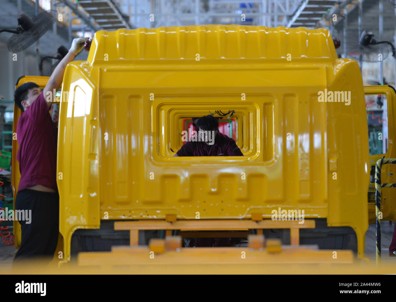 --FILE--A Chinese worker assembles vehicles on the assembly line at an ...