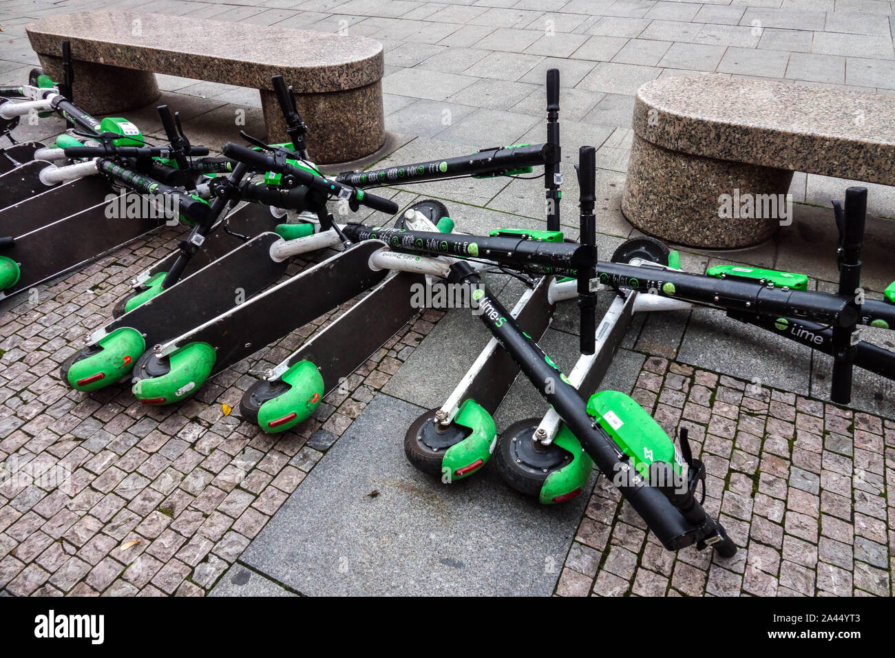 Electric scooters lying on the ground, obstruct the pavement, sidewalk, Prague street Czech
