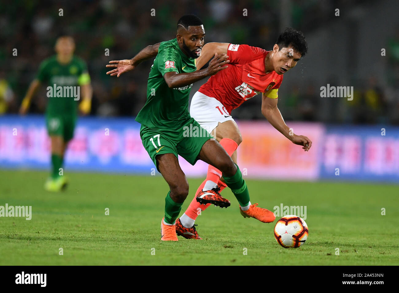 French-born Congolese football player Cedric Bakambu of Beijing Sinobo Guoan F.C., the black man, keeps the ball during the 23th round of Chinese Foot Stock Photo