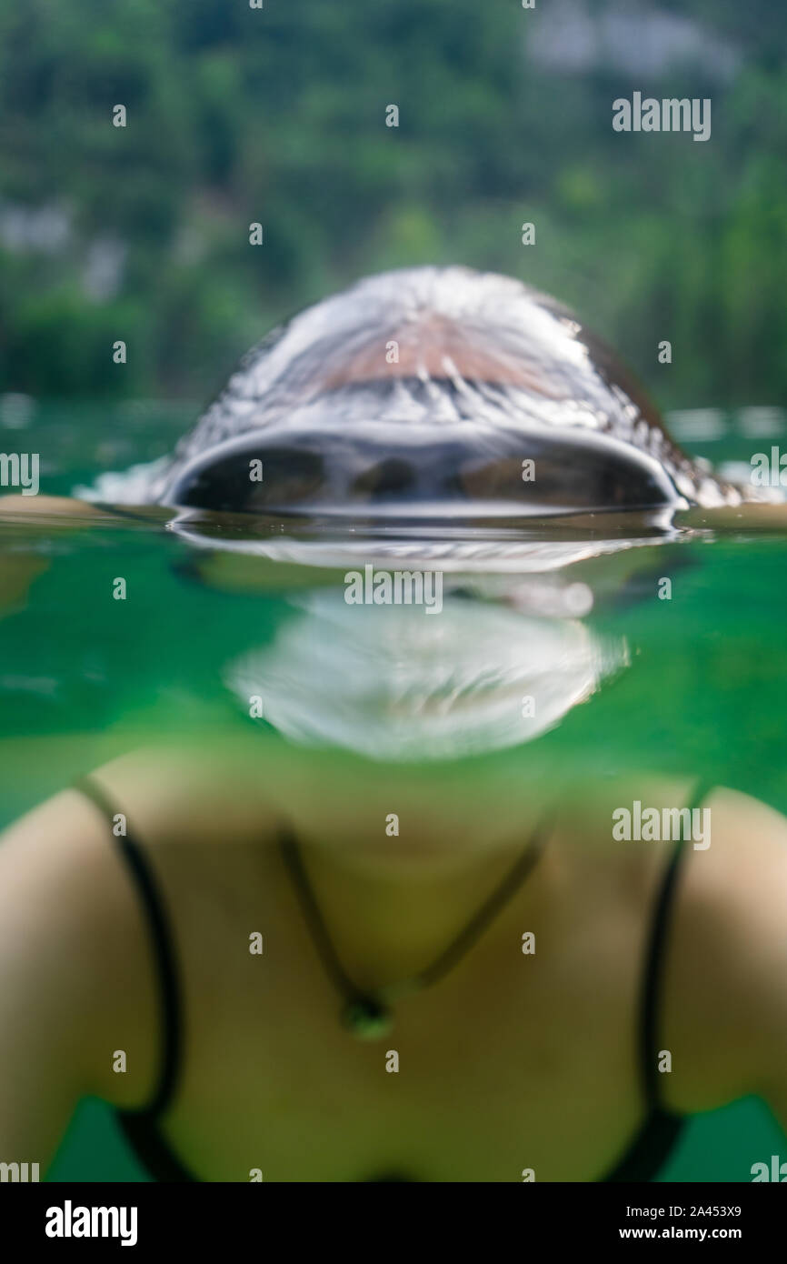 Half water half surface shot of a swimmer with mask at the Koenigssee (Königssee) in the Berchtesgadener Land, Bavaria, Germany Stock Photo