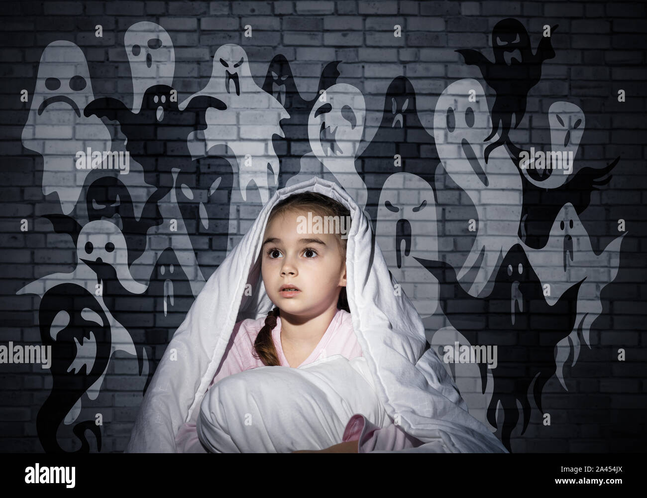 Scared girl with pillow hiding under blanket Stock Photo Alamy