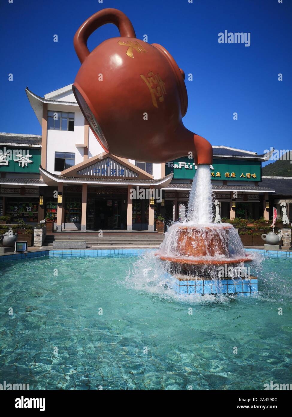 A giant floating teapot and teacup water fountain is displayed at an