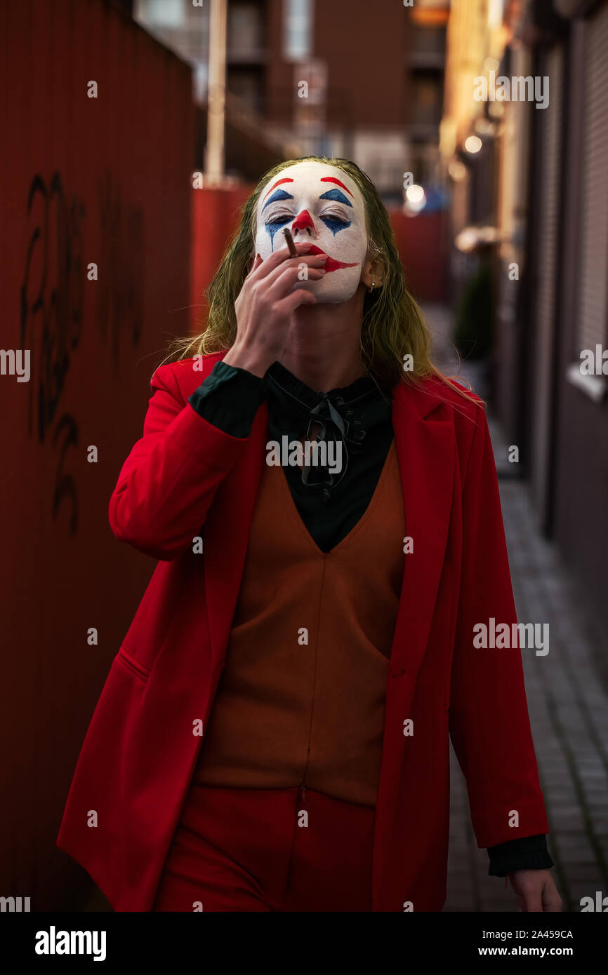 Young Woman With Joker Makeup And Costume Walks Smoking Stock Photo Alamy