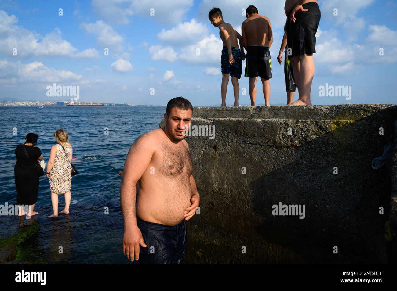 Men and women on the shore of the Sea of Marmara, Istanbul, Turkey Stock Photo