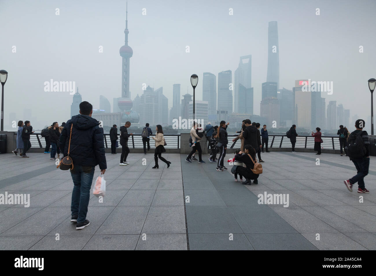 28 November 2018: Shanghai, China - A typical day on The Bund, China, looking towards Pudong district. People sightseeing in the thick air pollution. Stock Photo