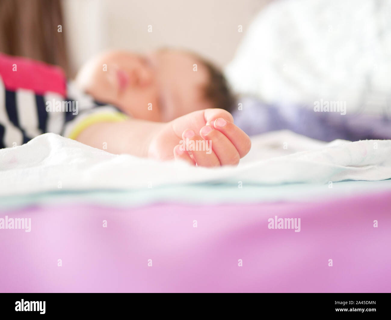 baby sleeps in parents bed. arms outstretched baby's restful sleep. close-up. child 0-1 years old. adorable lovely baby sleeps calmly in bed, has a Stock Photo