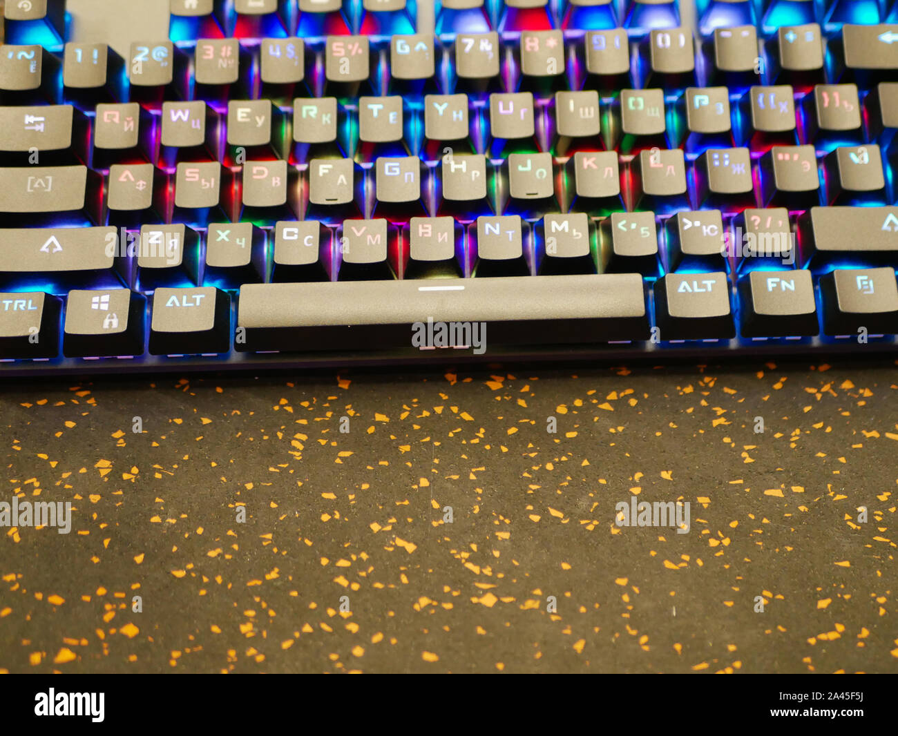 RGB keyboard. A colorful keyboard shimmers with different colors. lying on the table. Soft bokeh Stock Photo