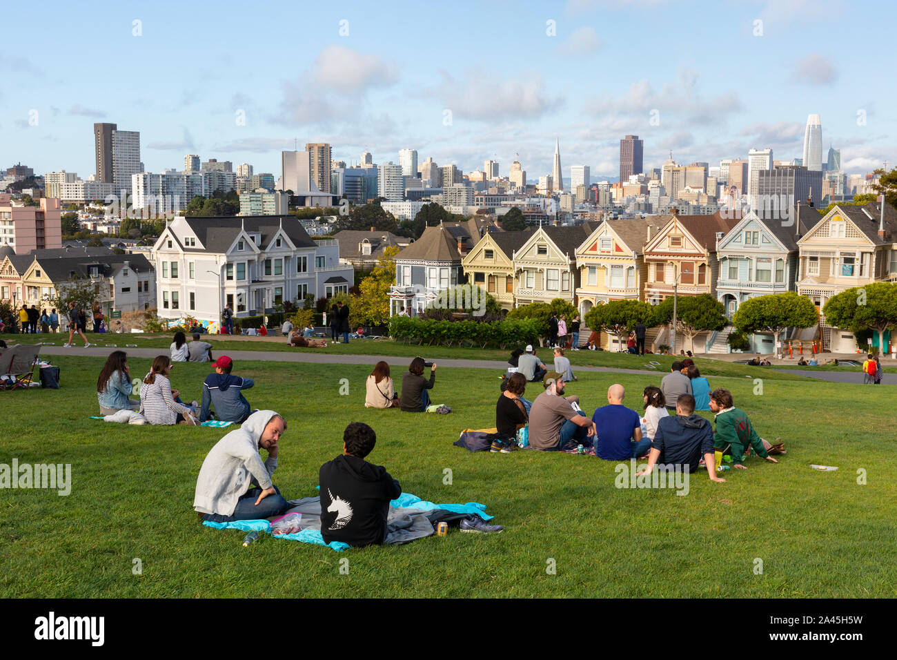 SAN FRANCISCO, USA - SEPTEMBER  8, 2019 : People relaxing in Alamo Square Park on a warm day with a view of the famous Painted Ladies and city skyline Stock Photo