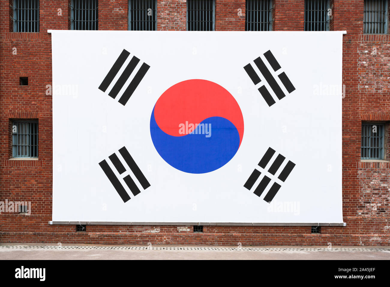 Giant South Korean flag on the red bricks wall of Seodaemun prison hall a former Japanese prison in Seoul South Korea Stock Photo