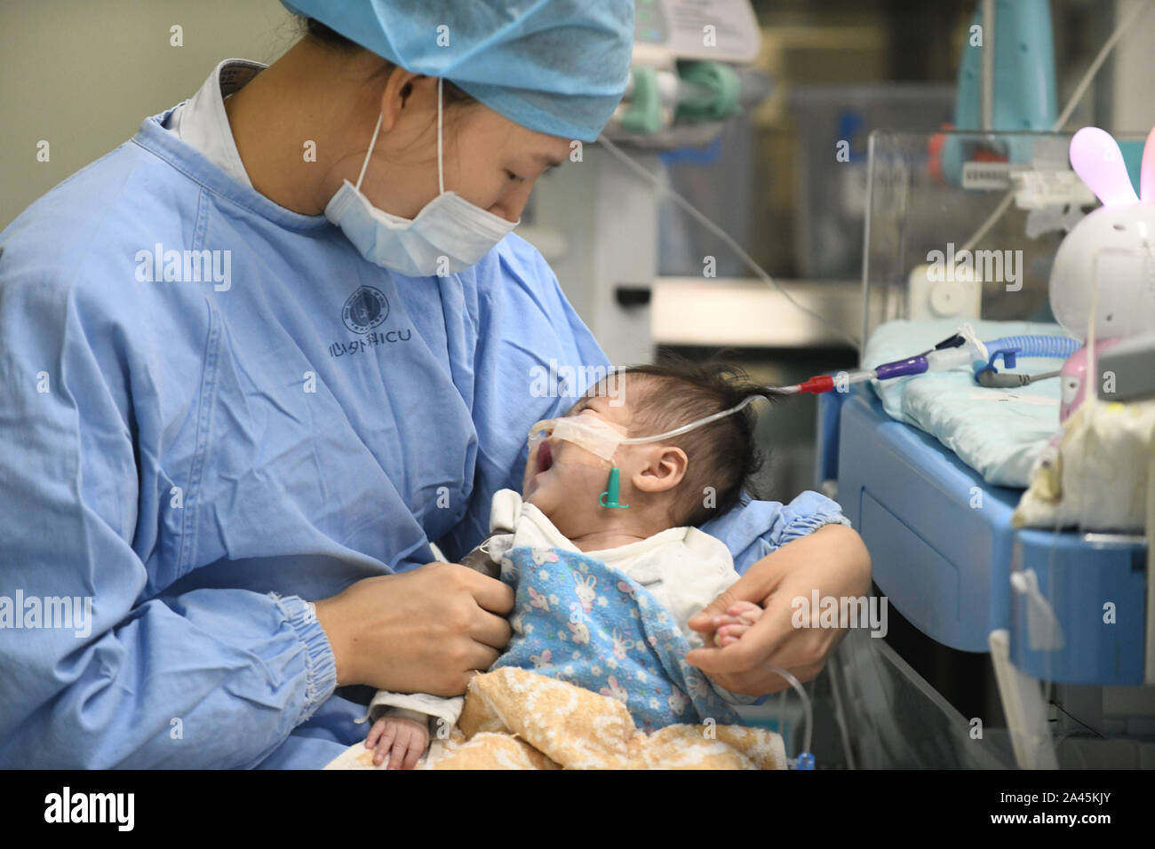 A nurse takes care of the baby who had a heart transplantation surgey