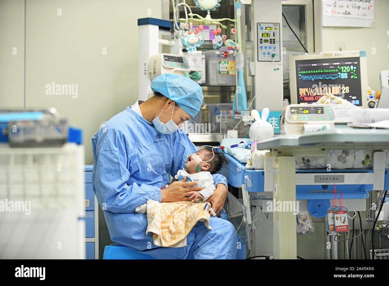 A nurse takes care of the baby who had a heart transplantation surgey