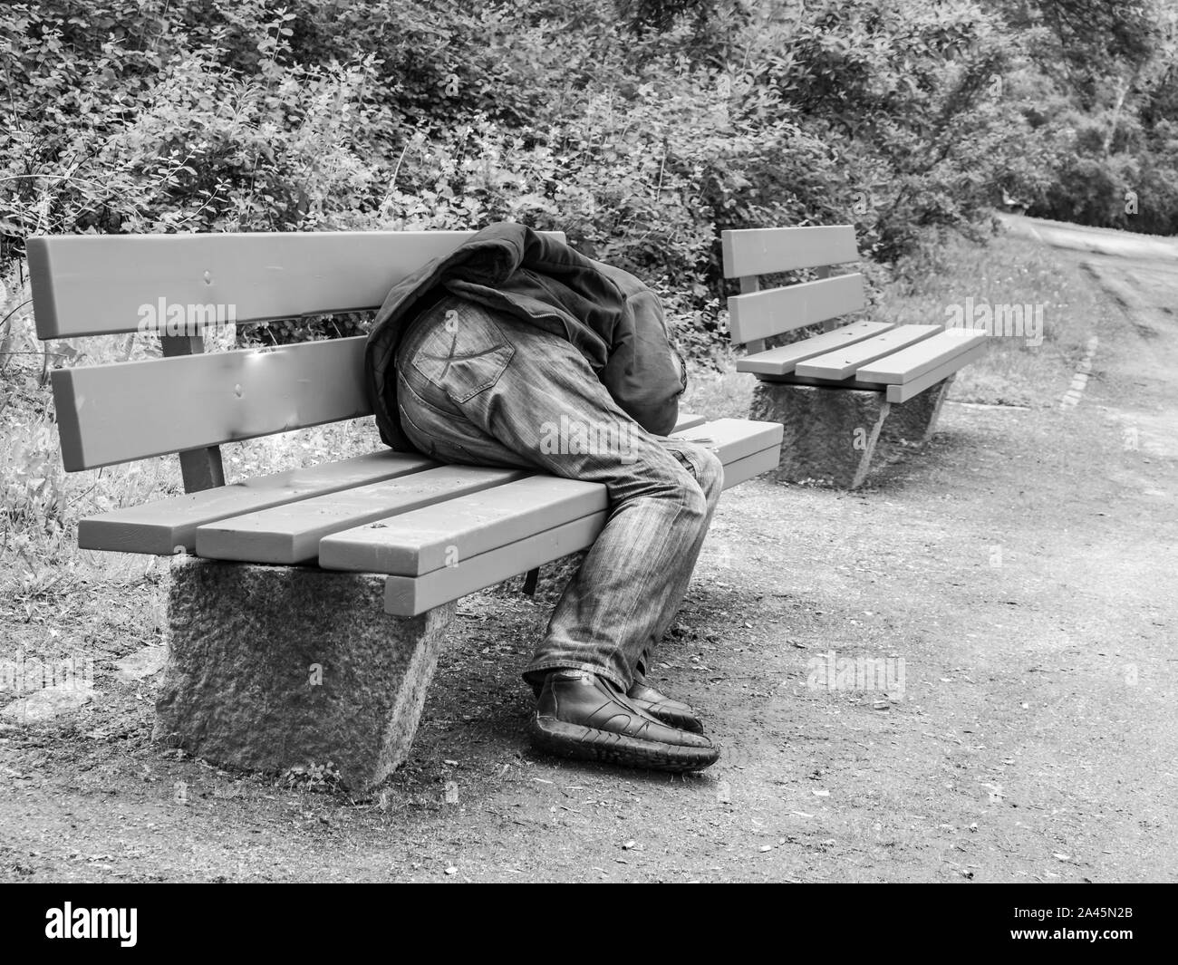 Man sleeping on a park bench in Germany Stock Photo