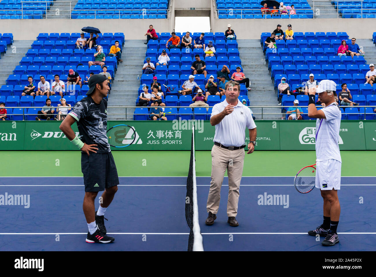 Japanese tennis player Yasutaka Uchiyama, left, plays against Chinese