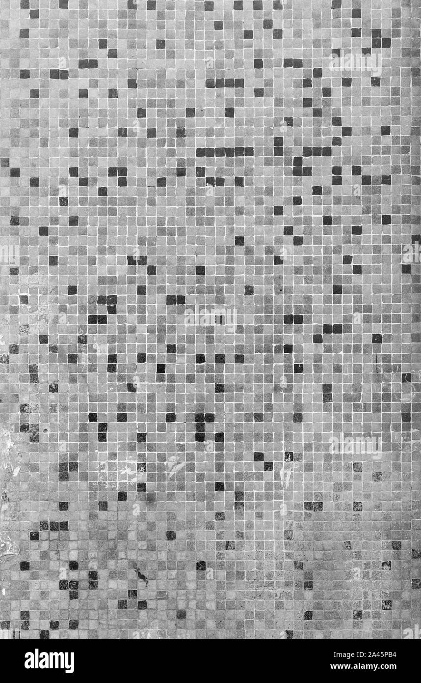 Close-up of a weathered, dirty and tiled mosaic pattern floor or wall. High resolution full frame textured background in black and white. Stock Photo
