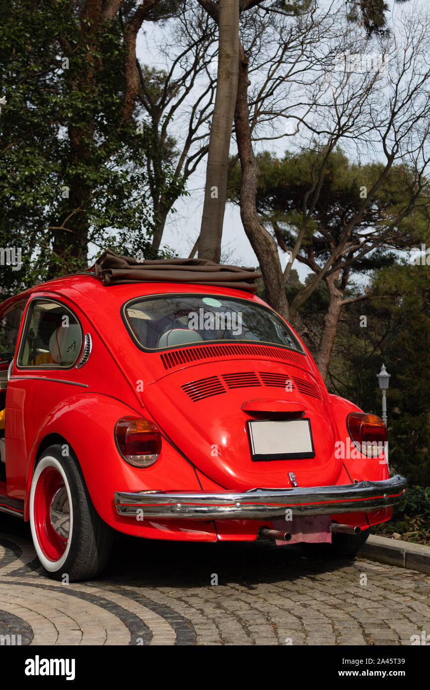 Red classic car has back view and trees in background Stock Photo