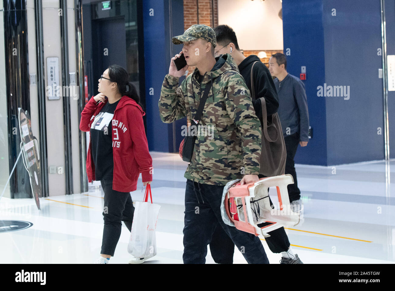 Consumers line up to buy the newly-released Adidas Yeezy, a ...