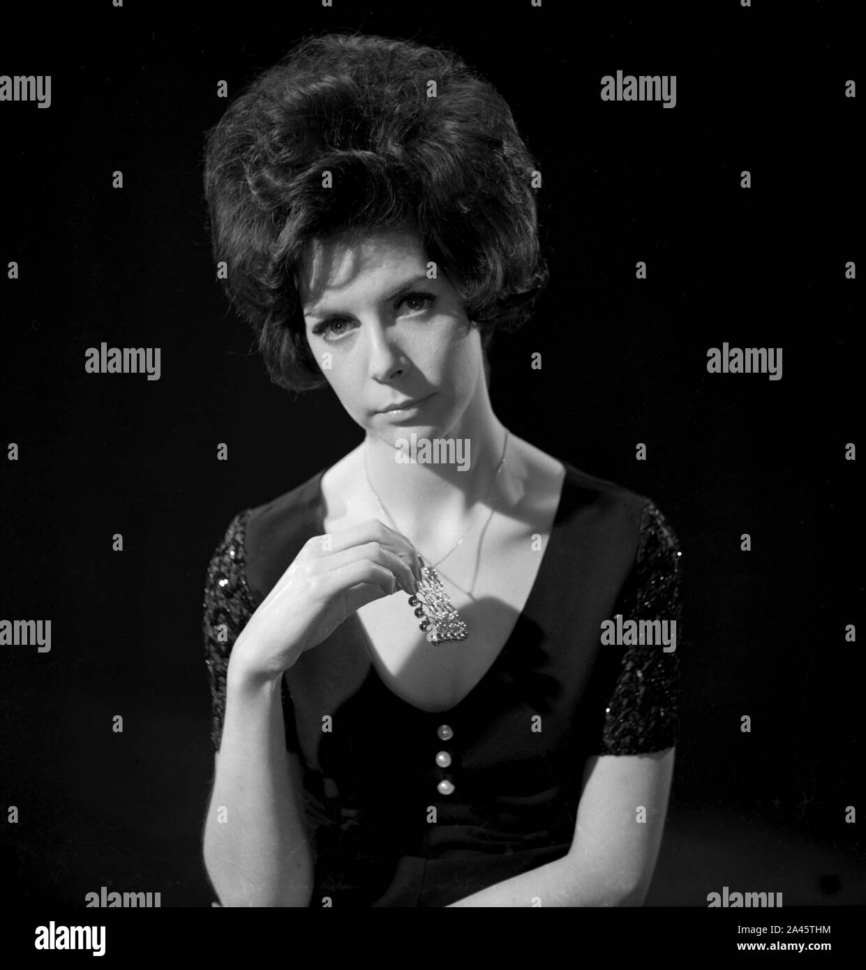 1960's photoshoot Female Model Thoughtful pose by model with bouffant hair with a moody black background. c1968  Photo by Tony Henshaw Archive Stock Photo