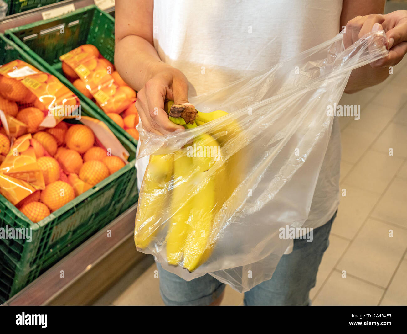 Customer packs bananas in plastic bag Stock Photo Alamy