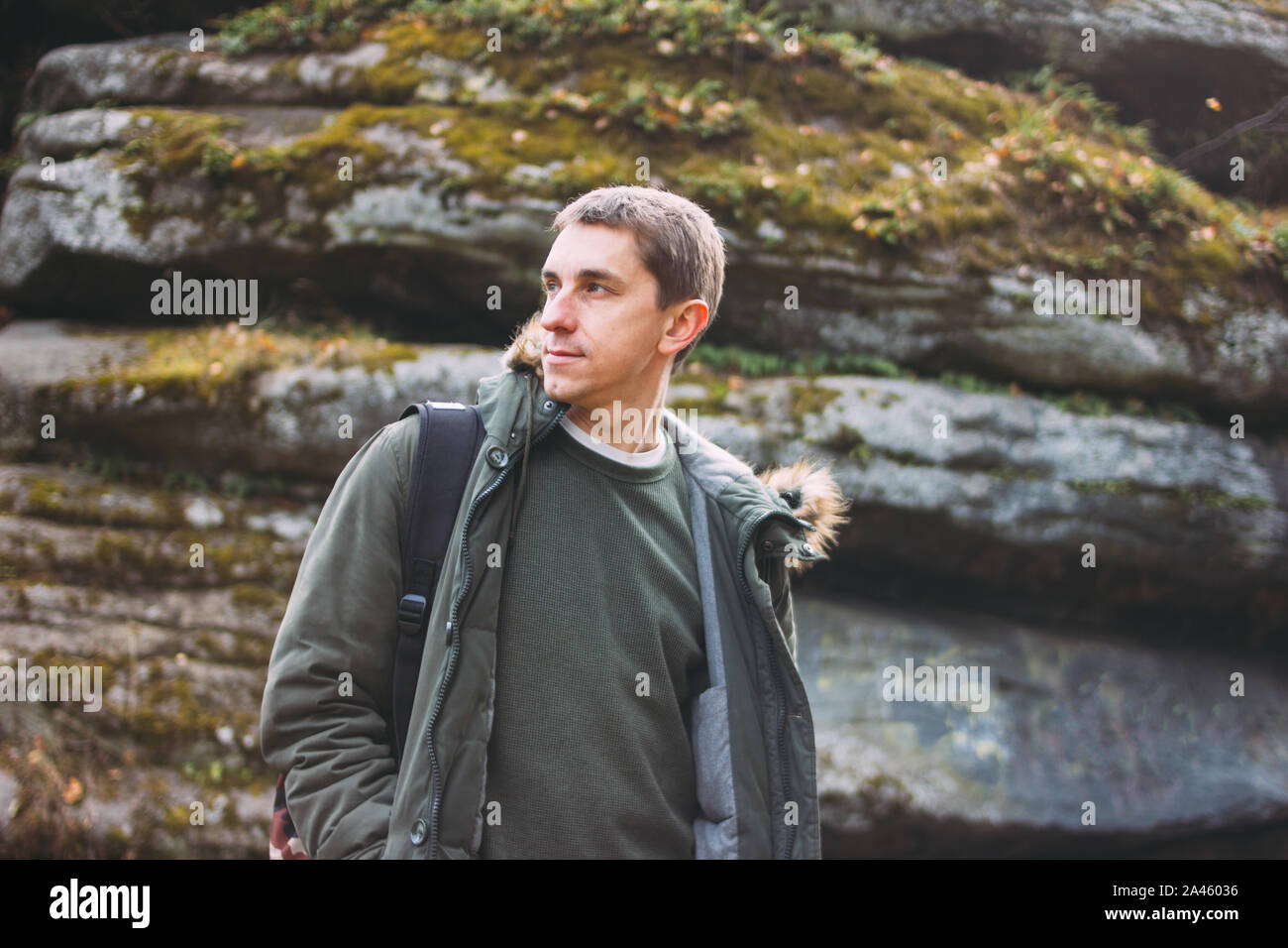 Portrait of young man in khaki parka jacket with backpack, travel adventure lifestyle Stock Photo