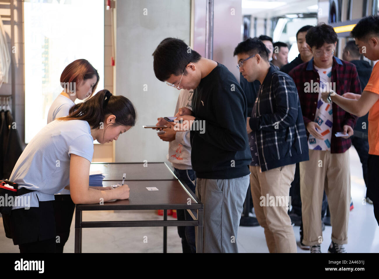 Consumers line up to buy the newly-released Adidas Yeezy, a ...