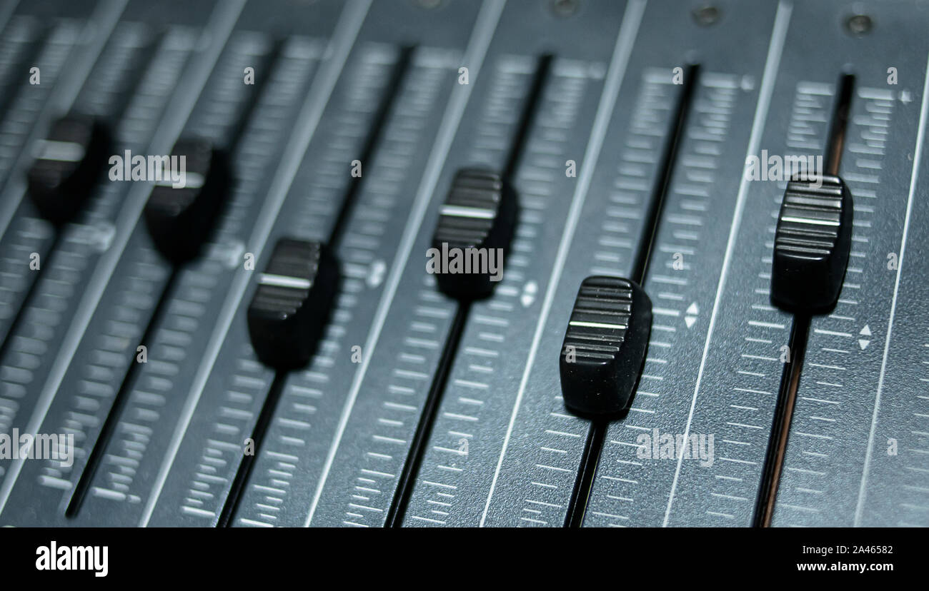 Multiple faders of a professional audio mixing console installed in a ...