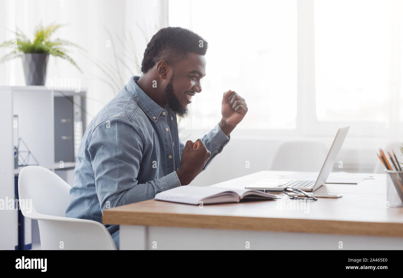 African American Businessman Celebrating Victory At Work Stock Photo