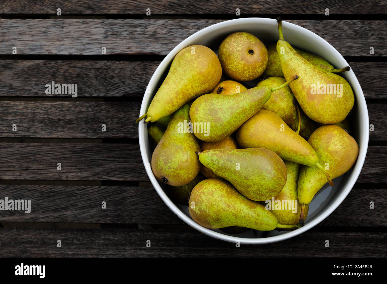 Conference pears, Pyrus communis, in a bowl on a table. These popular dessert pears are deliciously ripe and ready to be eaten Stock Photo