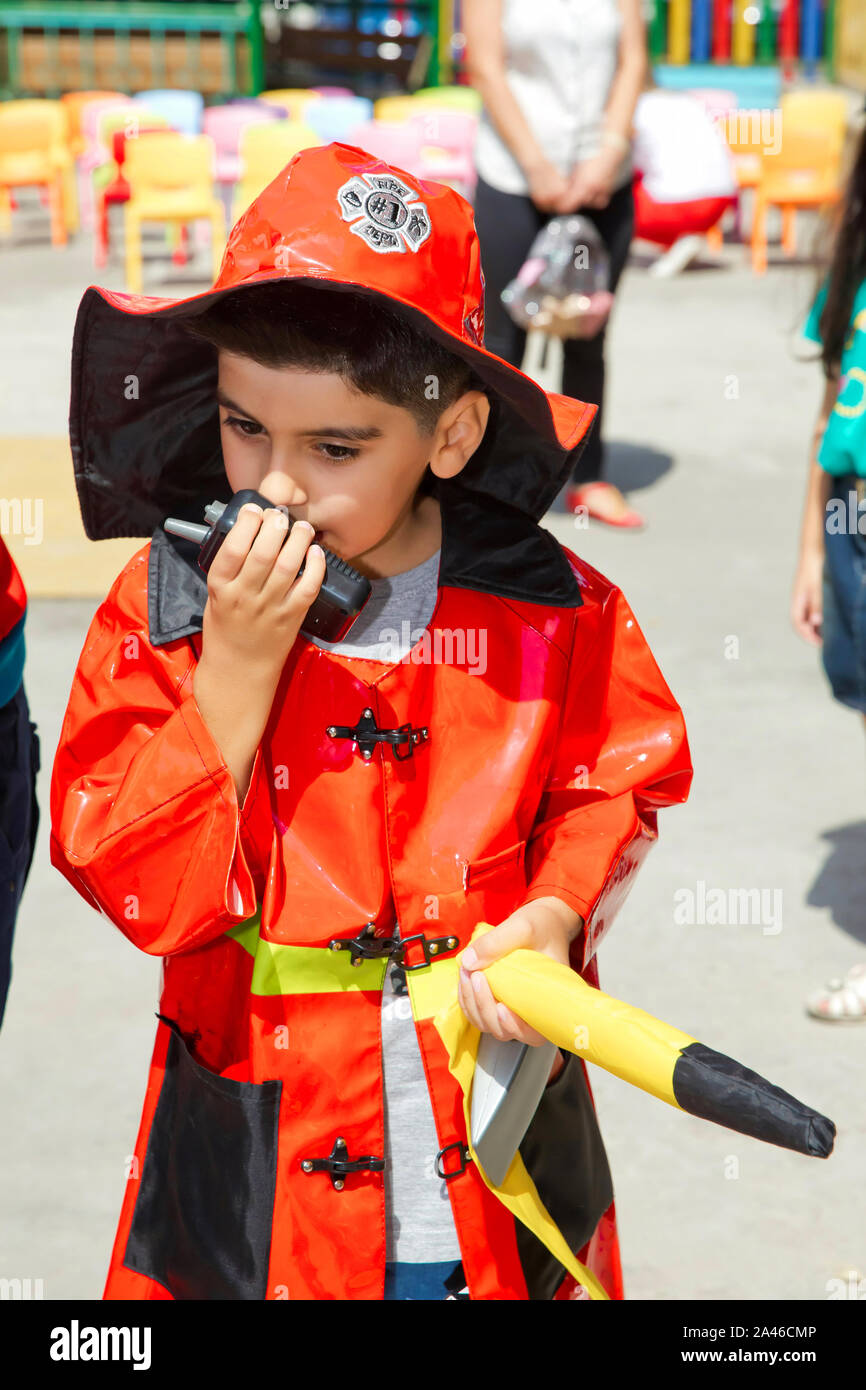 Baku, Azerbaijan - 04.09.2018: Birthday two years in the kindergarden . Children wearing fire extinguishers . Expressive cute toddler boy with fireman Stock Photo