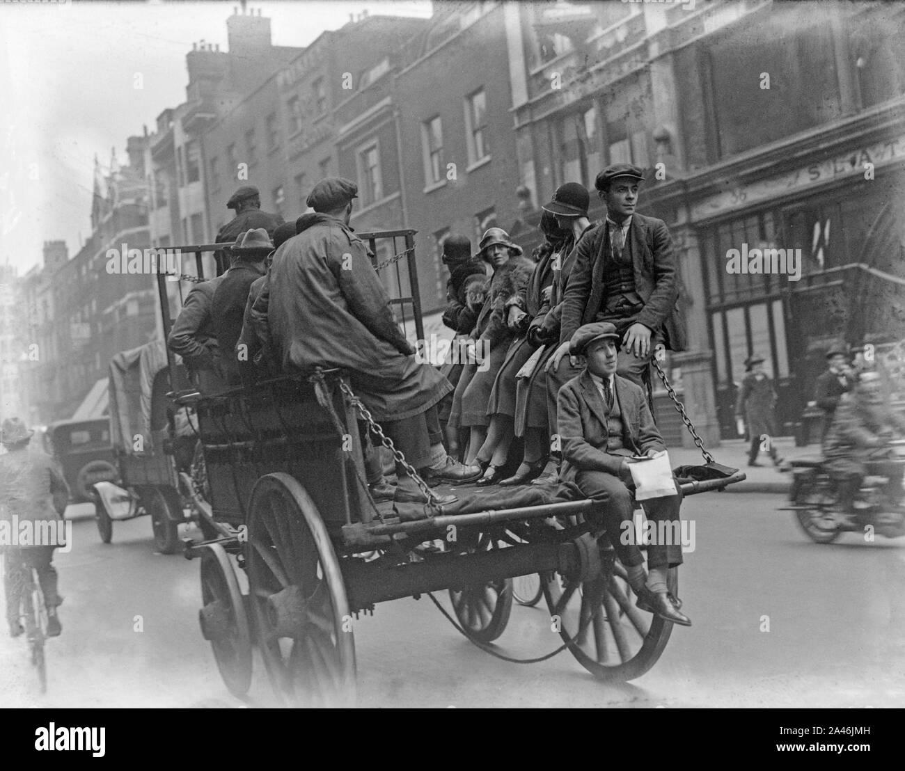 4th May 1926, London, England. As the General Strike begins in the United Kingdom, many public services are disrupted. Many people are unable to use the buses, so would travel around the city any way they could. The photo shows people in the back of a horse and cart. Stock Photo