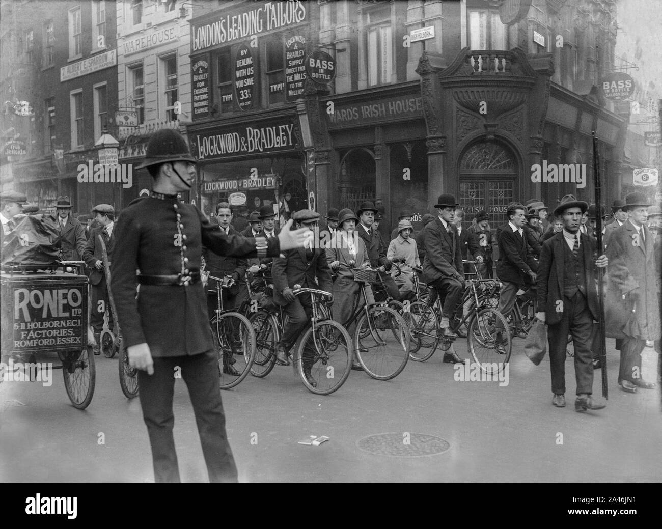 4th May 1926. High Holborn, London, England. A Policeman directs traffic, cyclists, and pedestrians, as the General Strike in the United Kingdom begins. Soon, the streets would see British Army tanks and armoured cars, as troops helped to m agnation order keep basic services running. Stock Photo