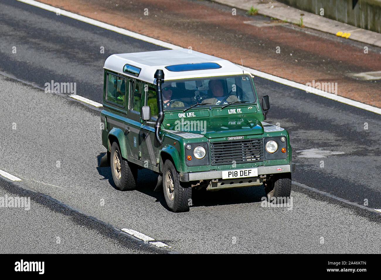 1997 90s nineties green Land Rover 110 Defender County Swtdi; with snorkel exhaust, UK Vehicular traffic, transport, modern, saloon cars, south-bound on the 3 lane M6 motorway highway. Stock Photo