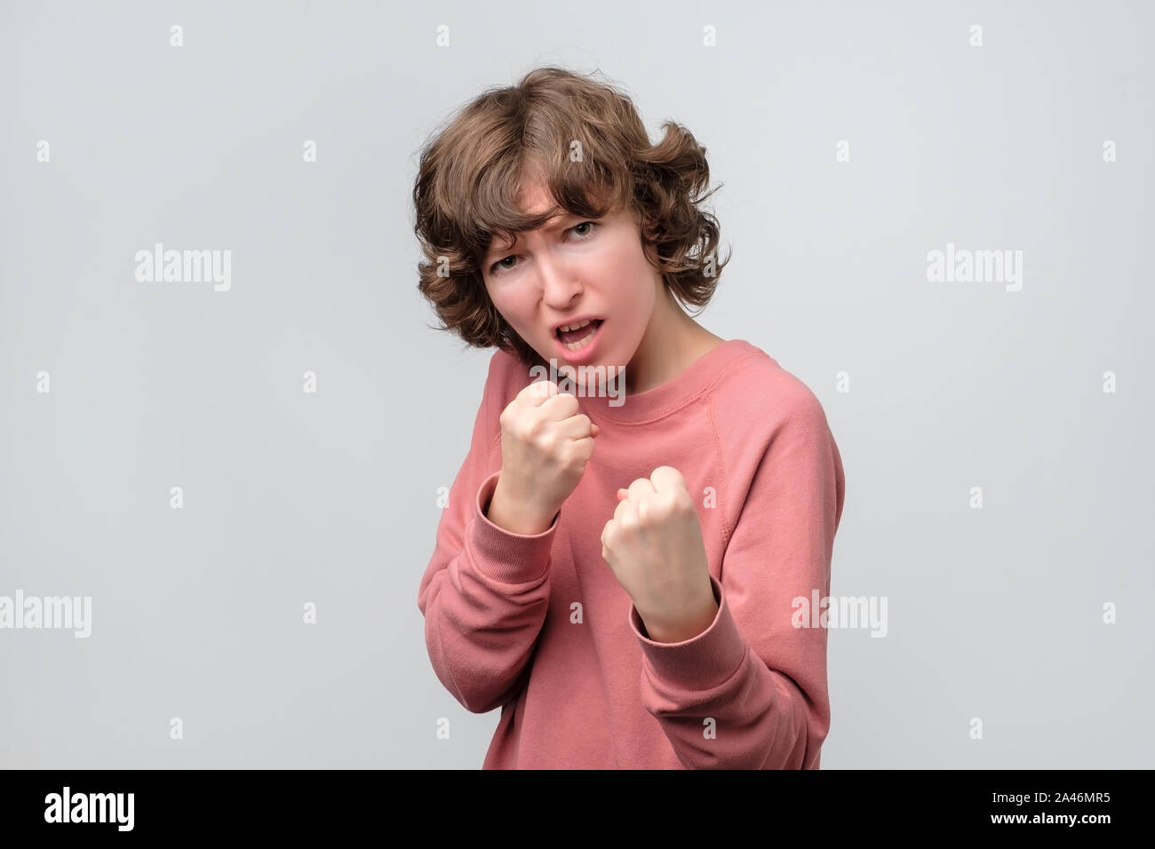 Strong woman keeping fists clenched in front of her defending herself Stock Photo