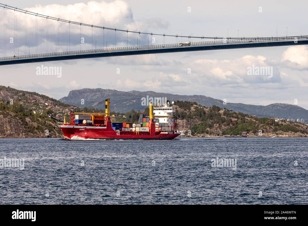 Small container vessel Rumba passing under Askoy (Askøy) suspension bridge, outside port of Bergen, Norway Stock Photo
