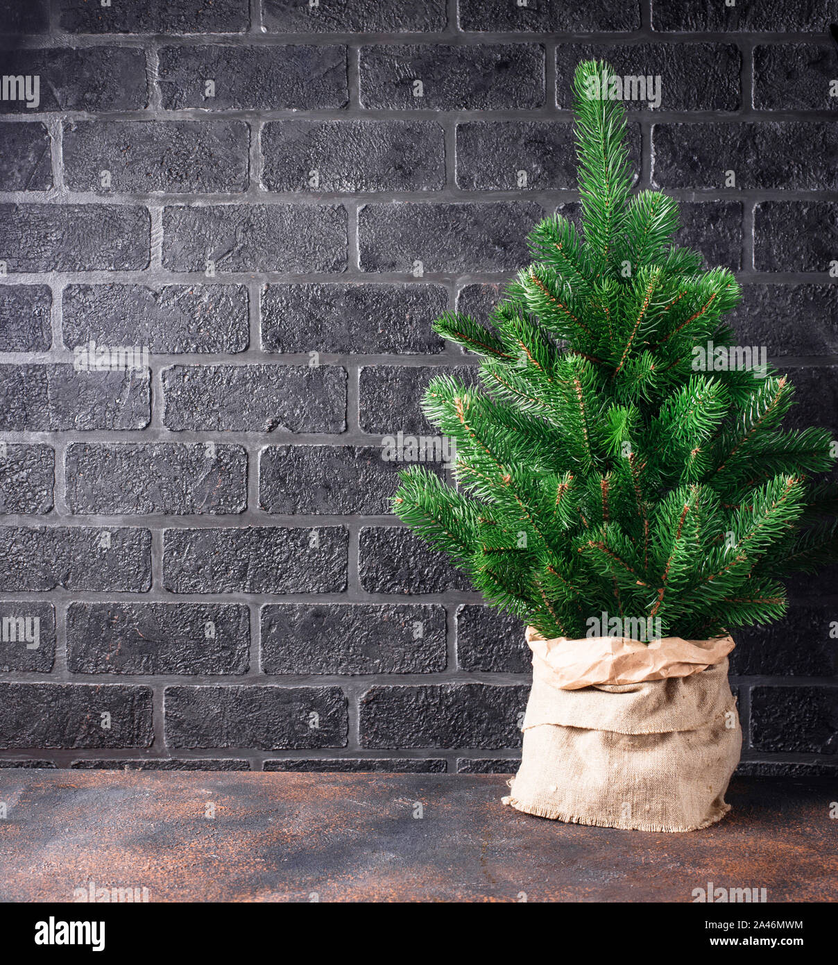 Christmas tree on brick wall background Stock Photo - Alamy