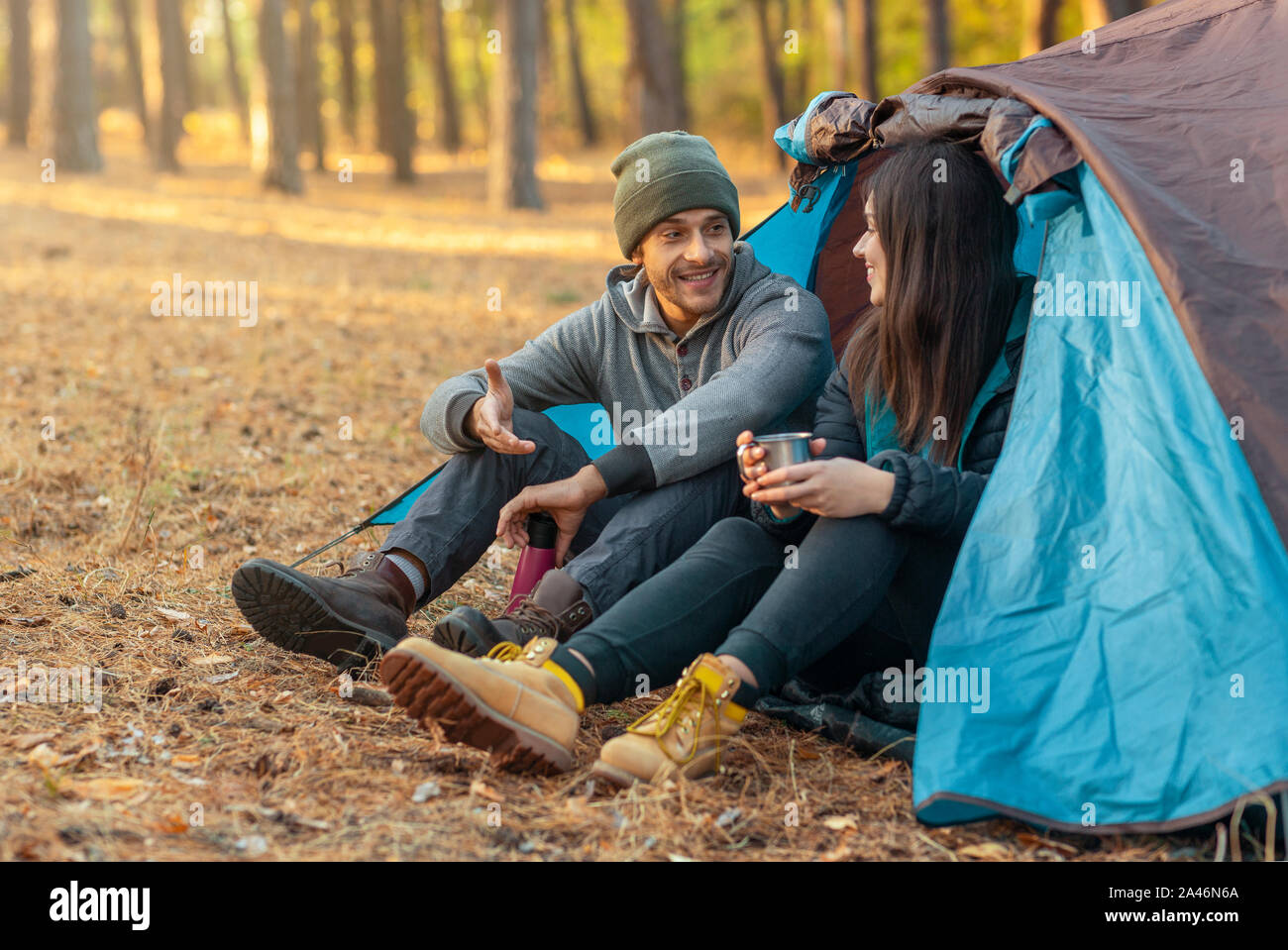 Romantic couple camping outdoors, sitting in tent Stock Photo - Alamy