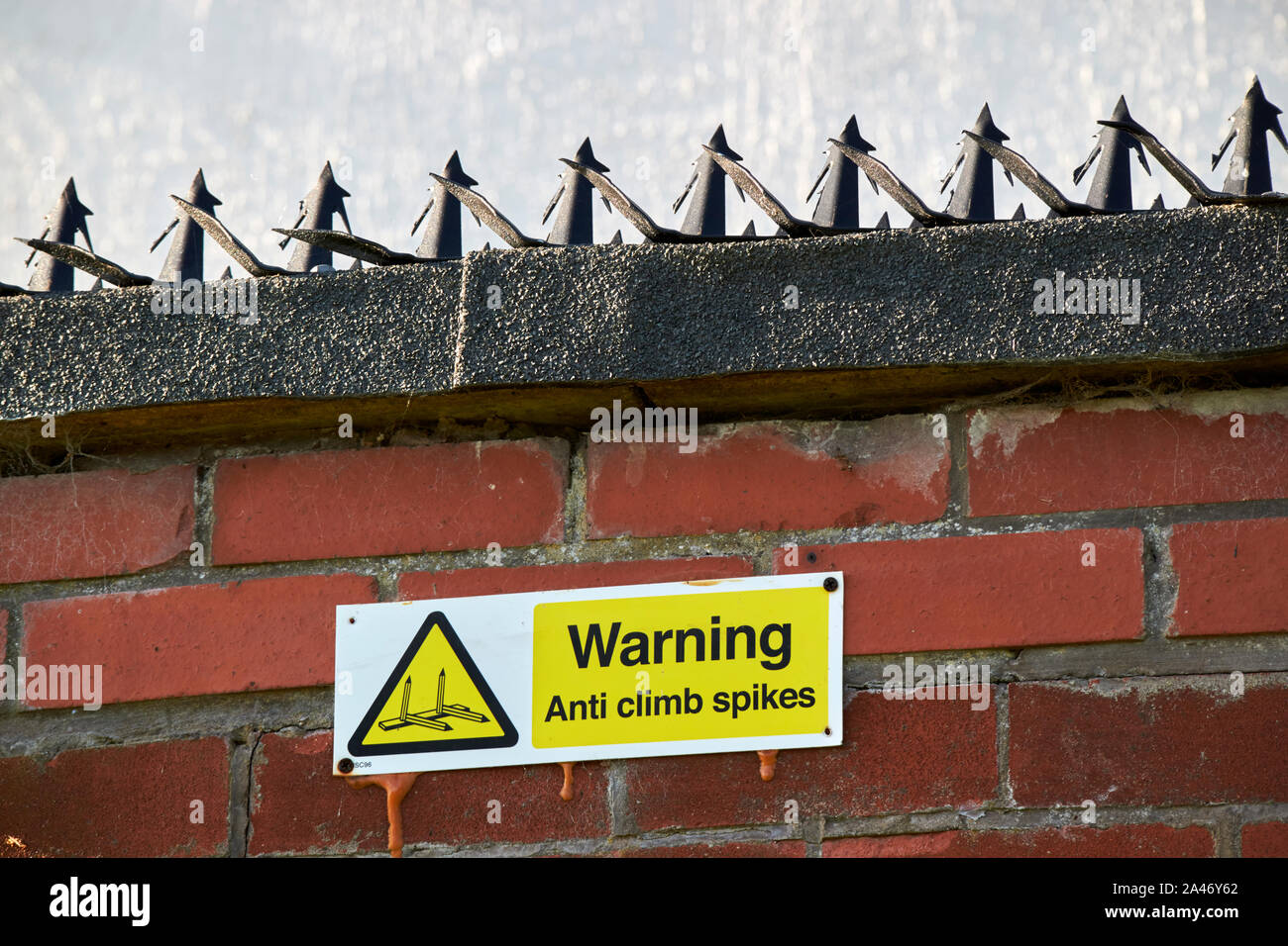 warning sign and anti climb spikes on a wall of a property Liverpool England UK Stock Photo