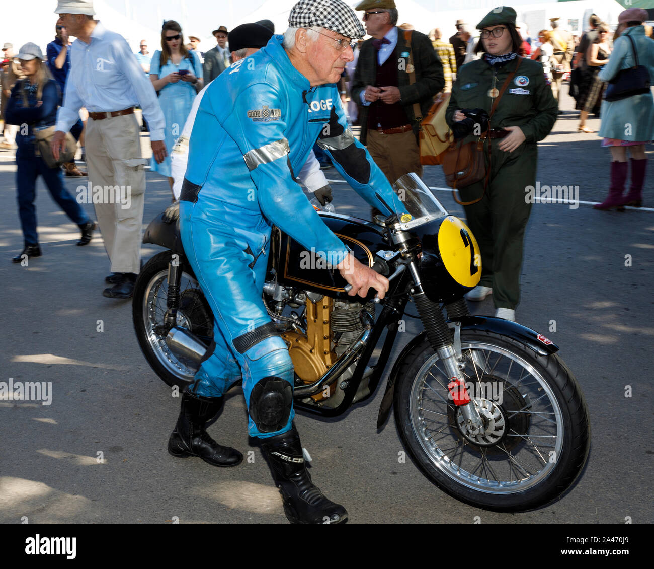 1956 AJS-Matchless 7R is wheeled through the paddock by Roger Ashby at the 2019 Goodwood Revival, Sussex, UK. Barry Sheene Memorial Trophy entrant. Stock Photo