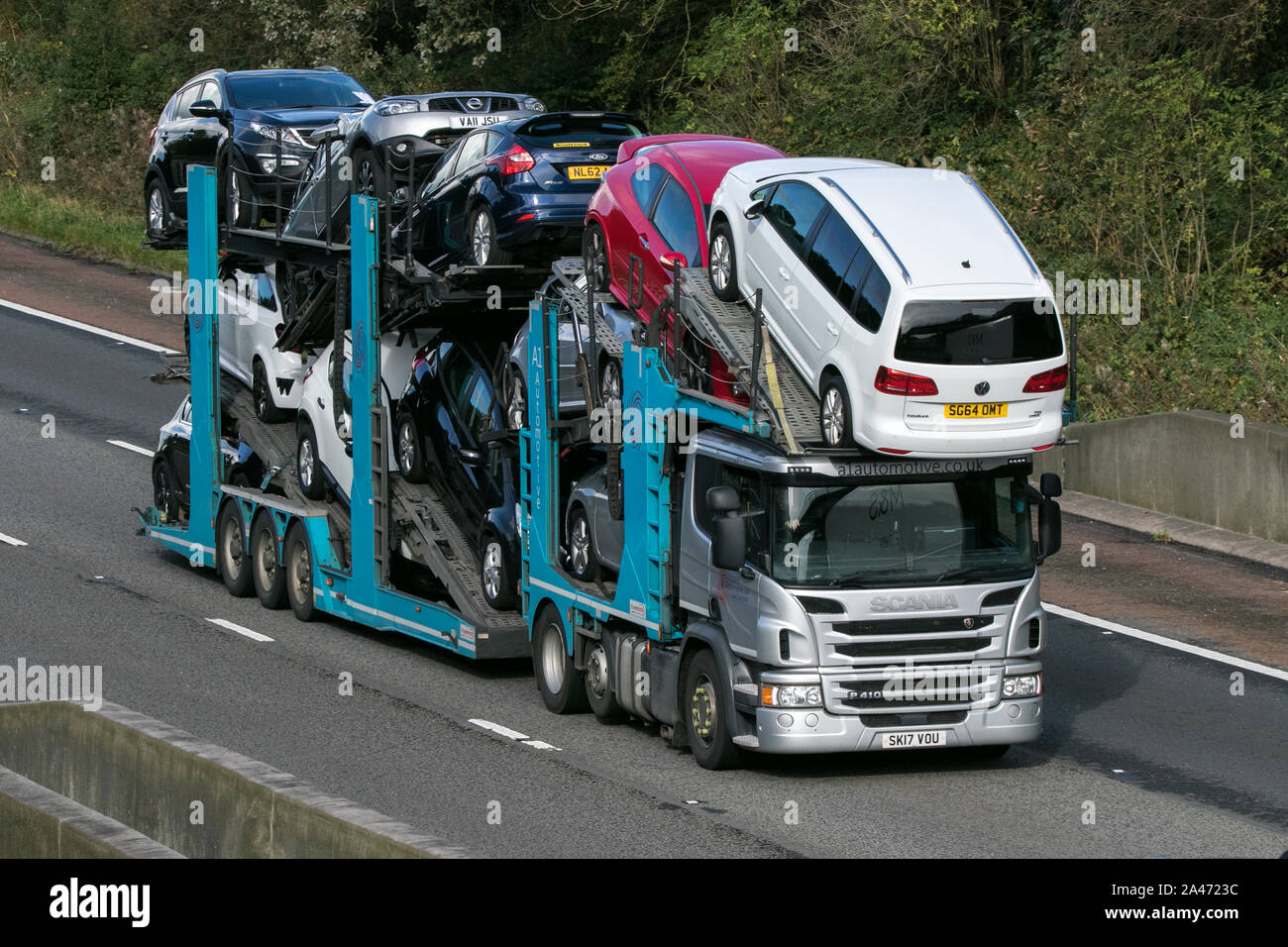 A Scania P410 heavy goods vehicle hgv transporting second hand cars on trailer southbound on the M6 motorway near Preston in Lancashire, UK Stock Photo