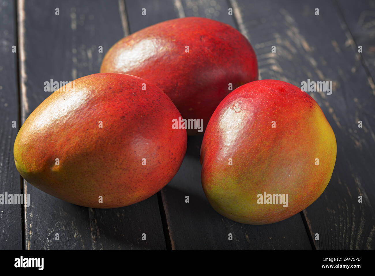 Mango fresh fruit on black wooden table. Stock Photo