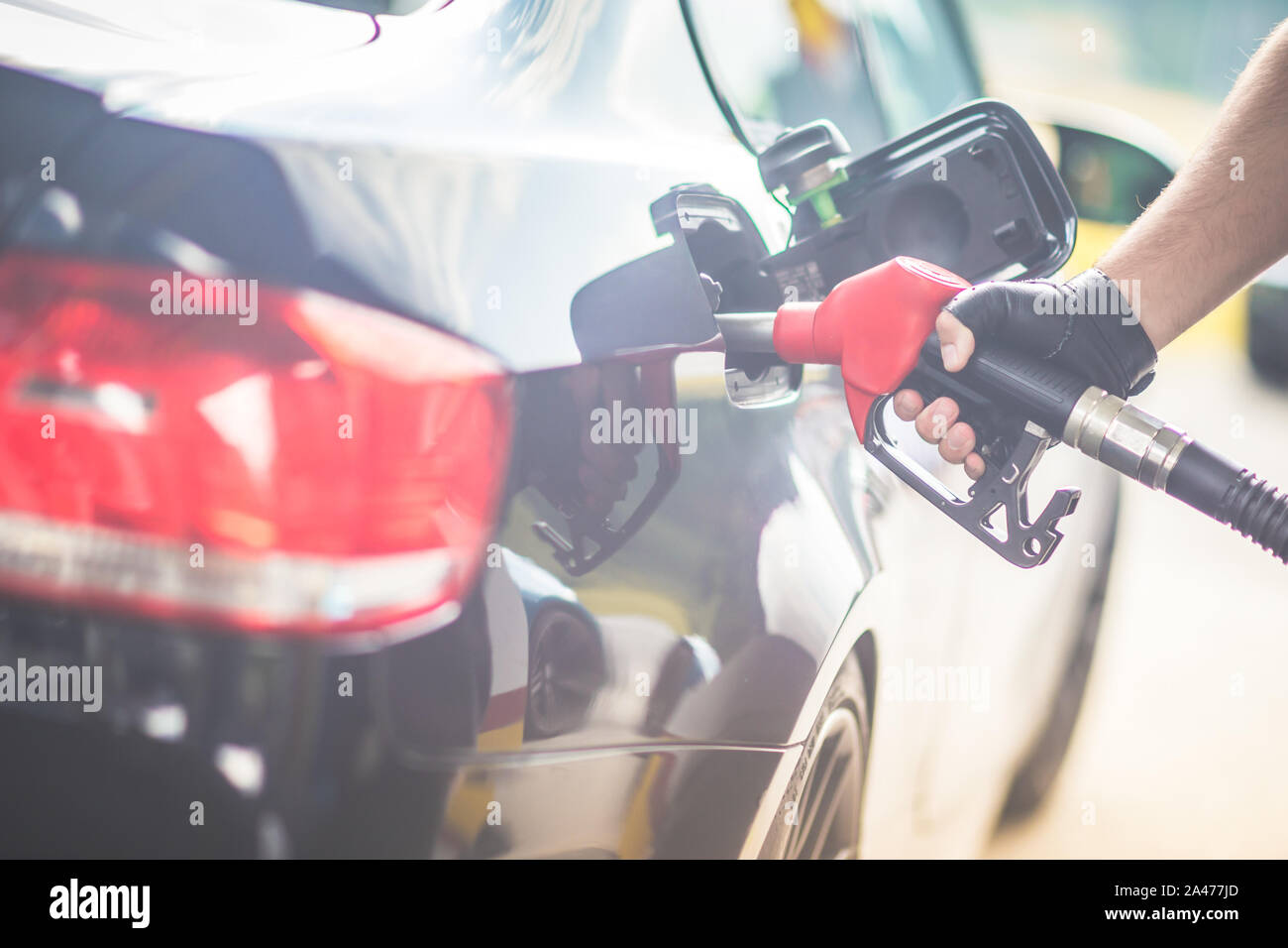 Pumping gas at gas pump. Closeup of man pumping gasoline fuel in car at