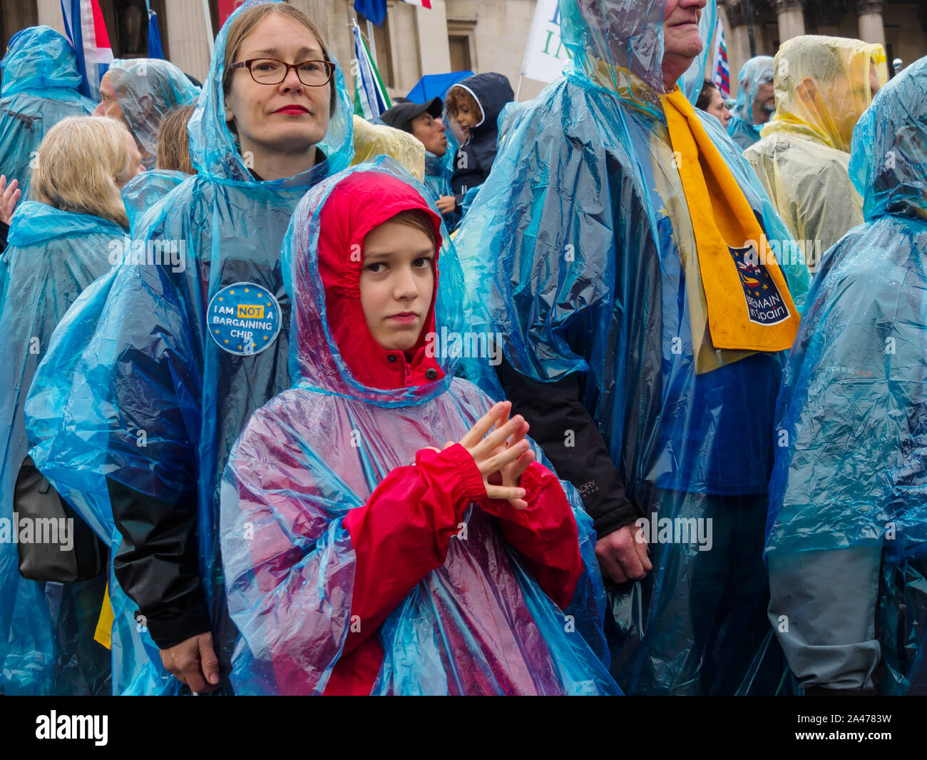 London, UK. 12th October 2019. Some of the 3 million EU citizens residents in the UK at an event organised by the3million organisation to express their love for the UK and to remind the Prime Minister ofe his broken promise to us on 1 June 2016. They wore ponchos in the blue and yellow of the European flag. The government settlement scheme is full of flaws and many who have applied have not been granted settled status, and government minister Brandon Lewis has stated that those who have failed to achieve it risk deportation. They held up copies of Vote Leave's broken promise and tore it up. Pe Stock Photo