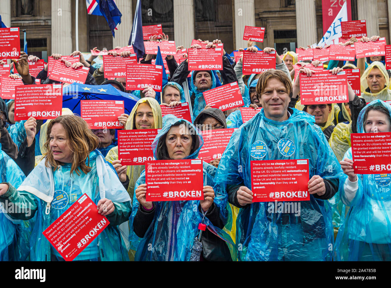 London, UK. 12th October 2019. People hold copies of Vote Leave's broken pledge to EU citizens living here. Some of the 3 million EU citizens residents in the UK at an event organised by the3million organisation to express their love for the UK and to remind the Prime Minister ofe his broken promise to us on 1 June 2016. They wore ponchos in the blue and yellow of the European flag. The government settlement scheme is full of flaws and many who have applied have not been granted settled status, and government minister Brandon Lewis has stated that those who have failed to achieve it risk depor Stock Photo